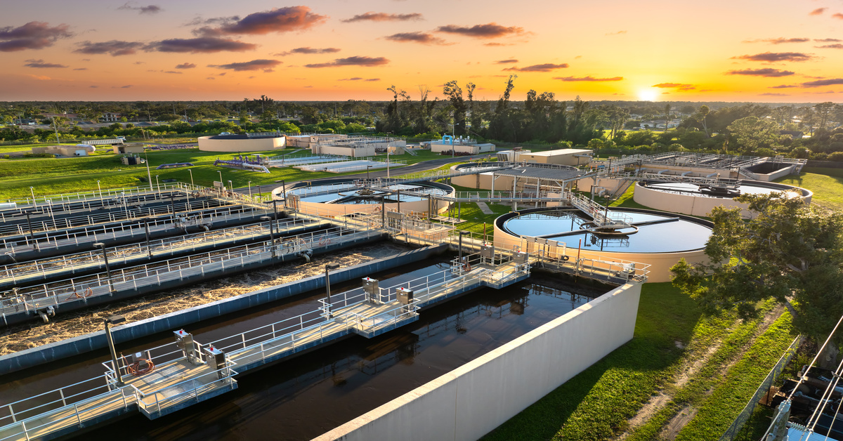 A large water treatment facility with industrial infrastructure and large water tanks for wastewater processing.