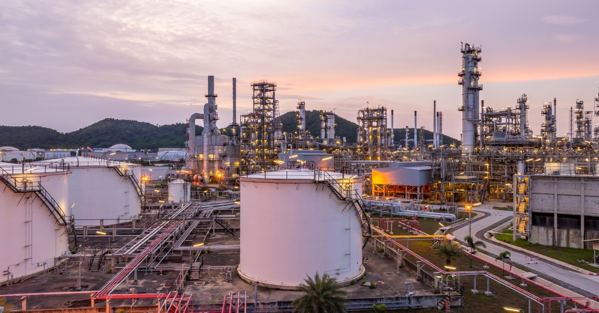 A landscape shot of a large, outdoor chemical facility with several storage tanks for holding materials.